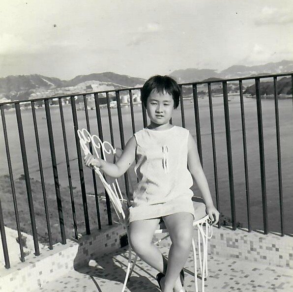 Childhood photo of architect Annie Chu sitting on a balcony by the water