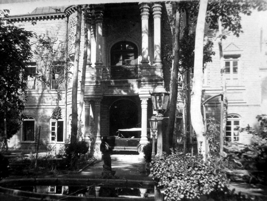 Exterior black and white shot of large home with pillars