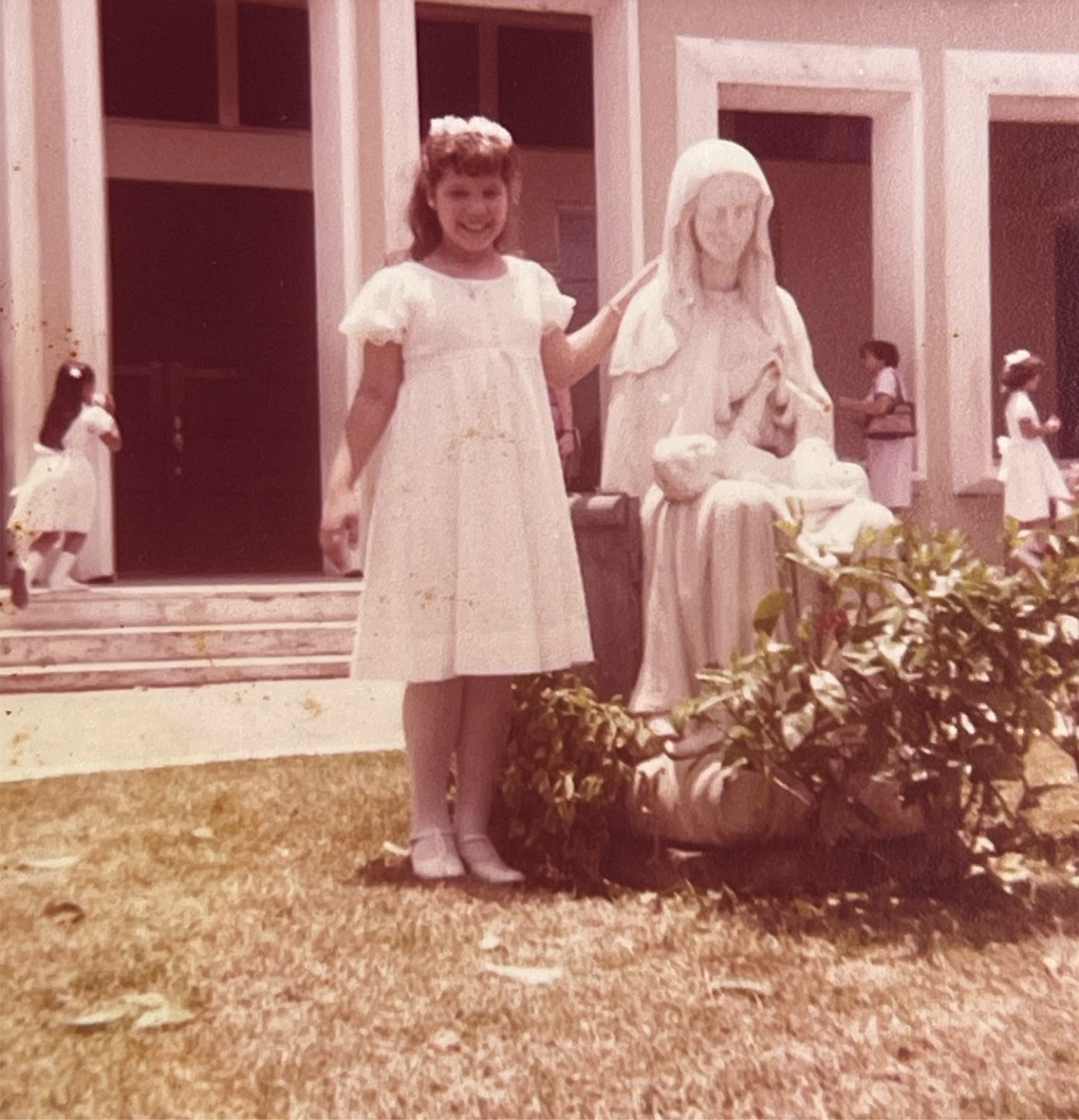 Childhood photo of artist Edra Soto in a white dress outside of church