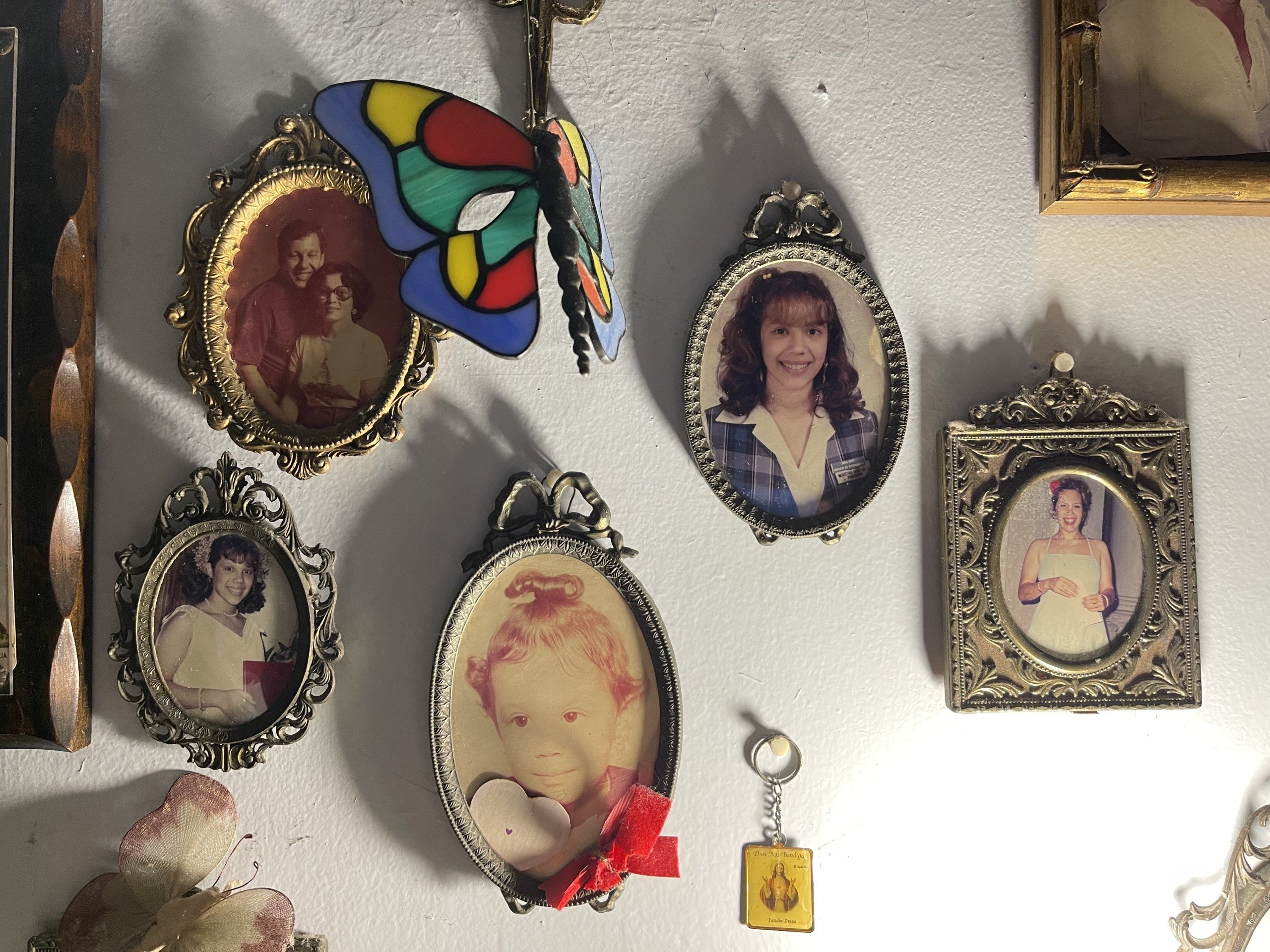 Framed photos on a white wall in artist Edra Soto’s childhood home.
