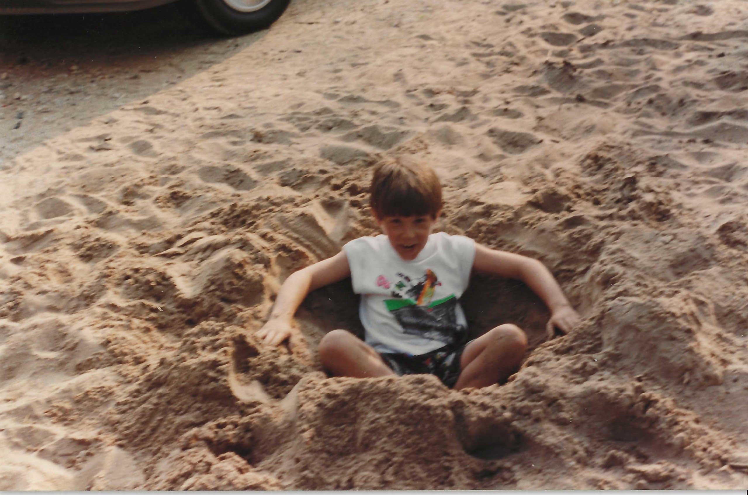 Jonathan Nesci as a child playing in the sand at the beach