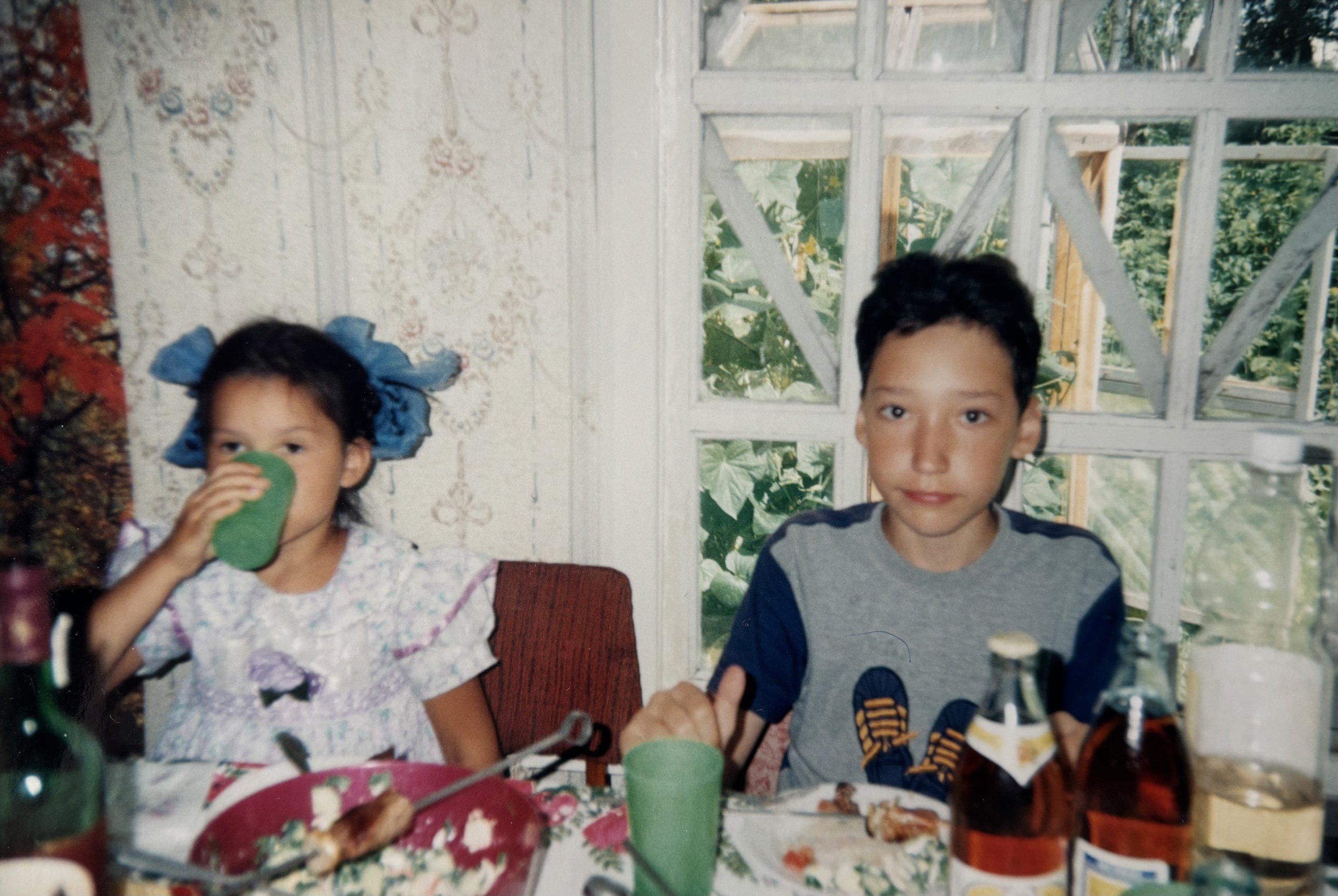 Julia Gamolina and cousin as children eating lunch in dacha