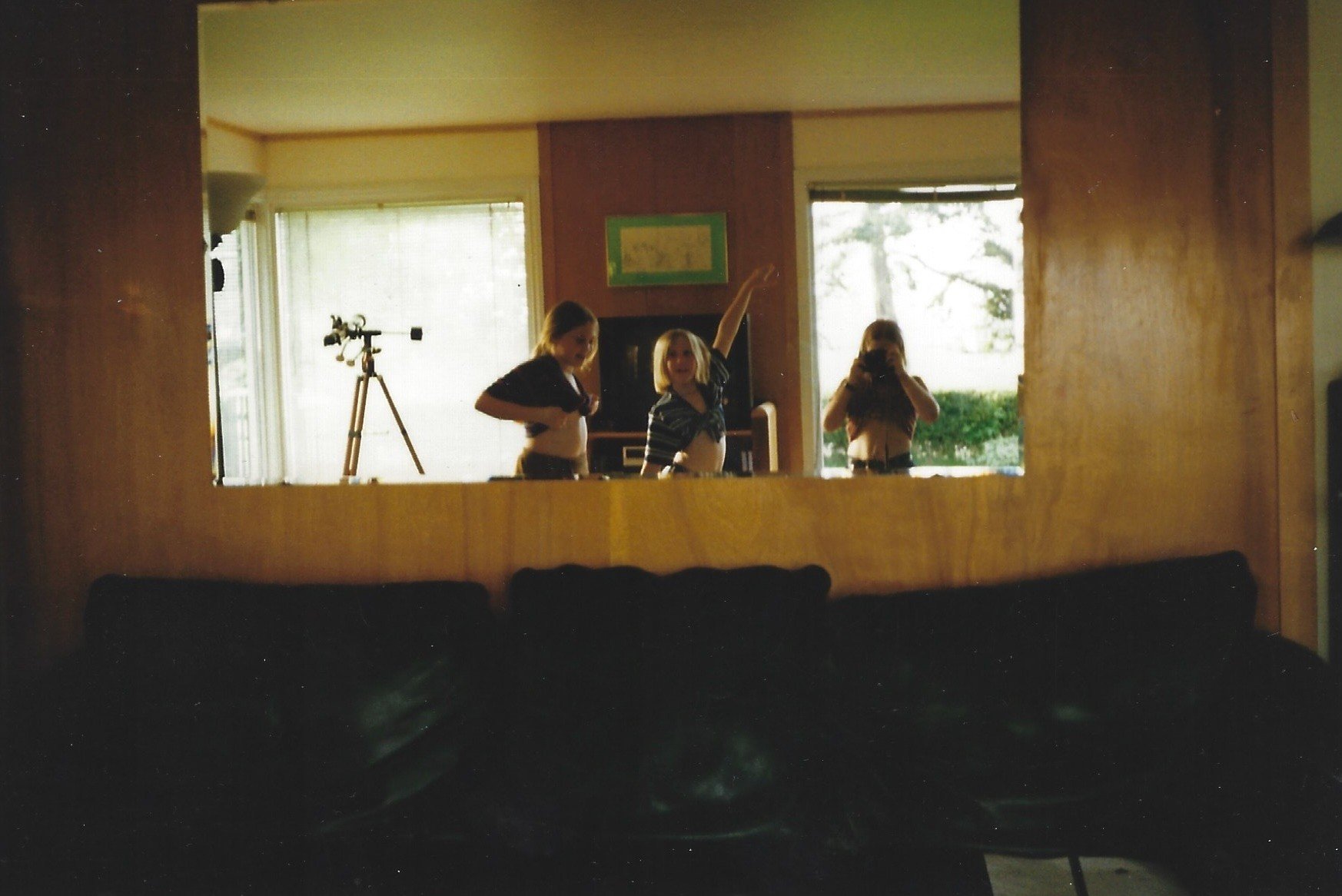 Three little girls playing in a mirror