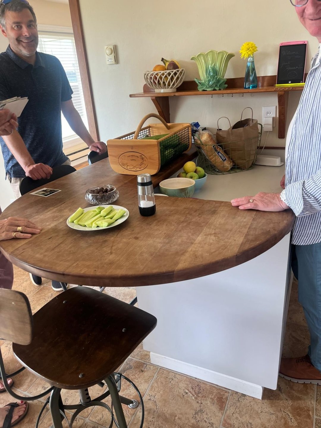 Two people standing at a beloved wooden kitchen table