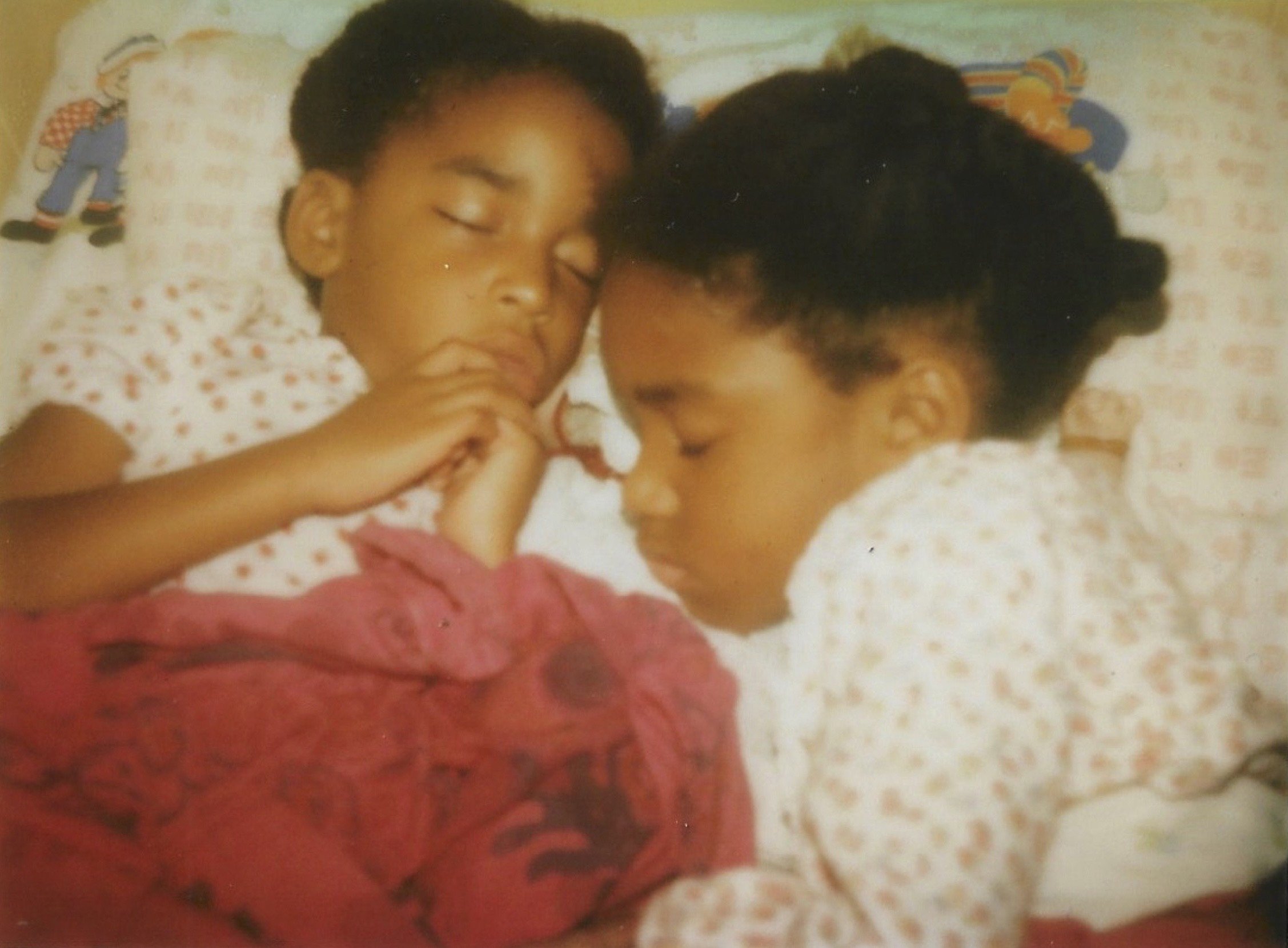 Two young sisters sleeping next to each other