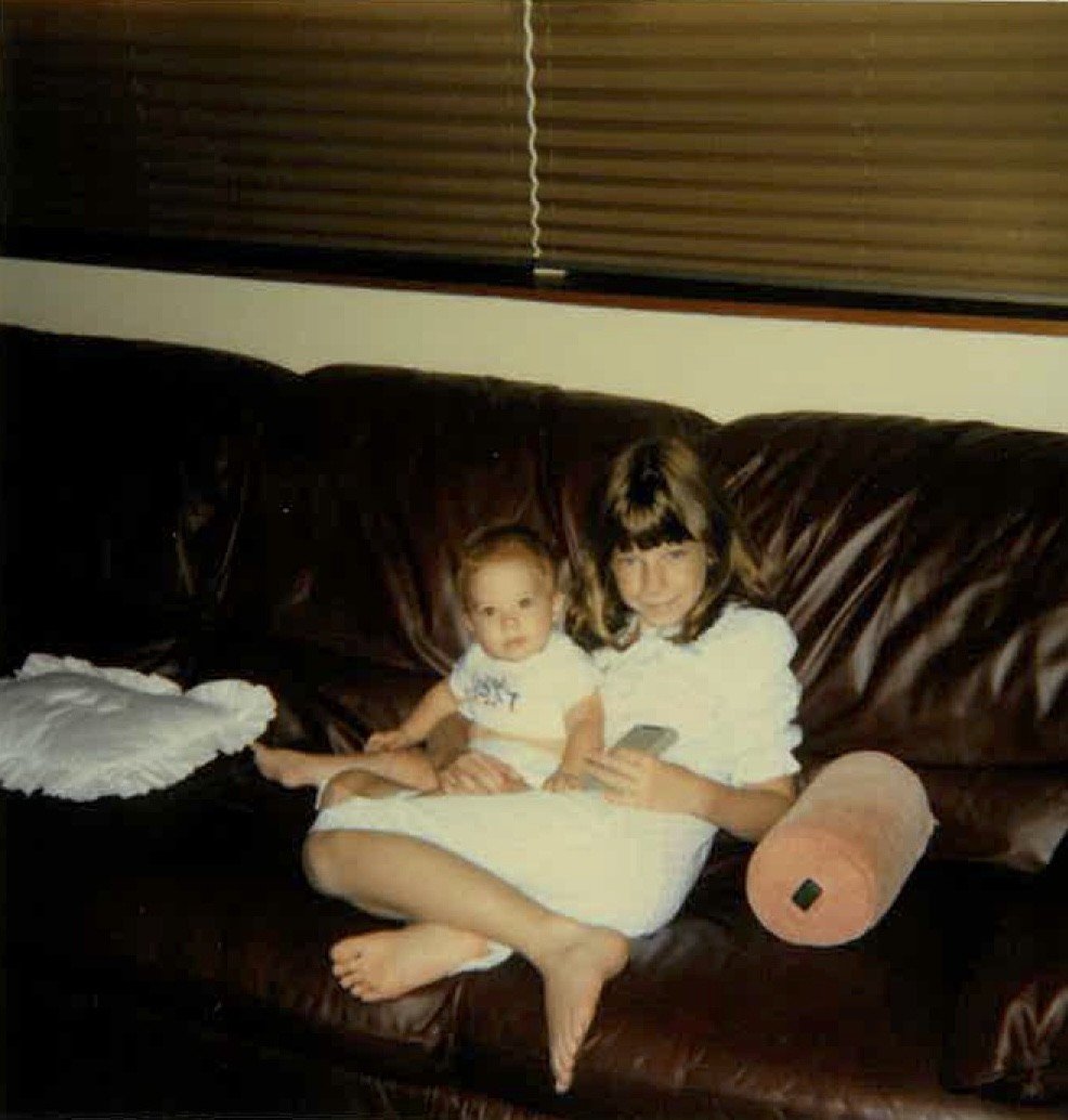 Young girl and baby sitting on Sam Klemick's childhood couch