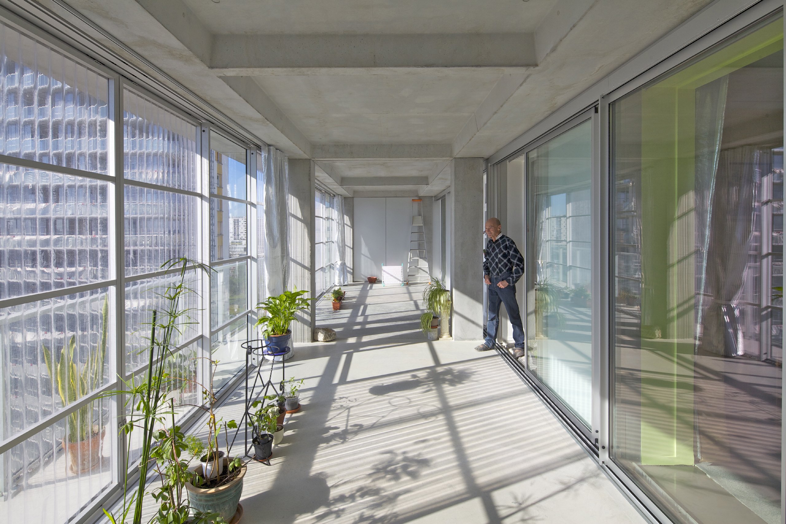 man walking into upper level sun room in Lacaton and Vassal's social housing in Bordeaux