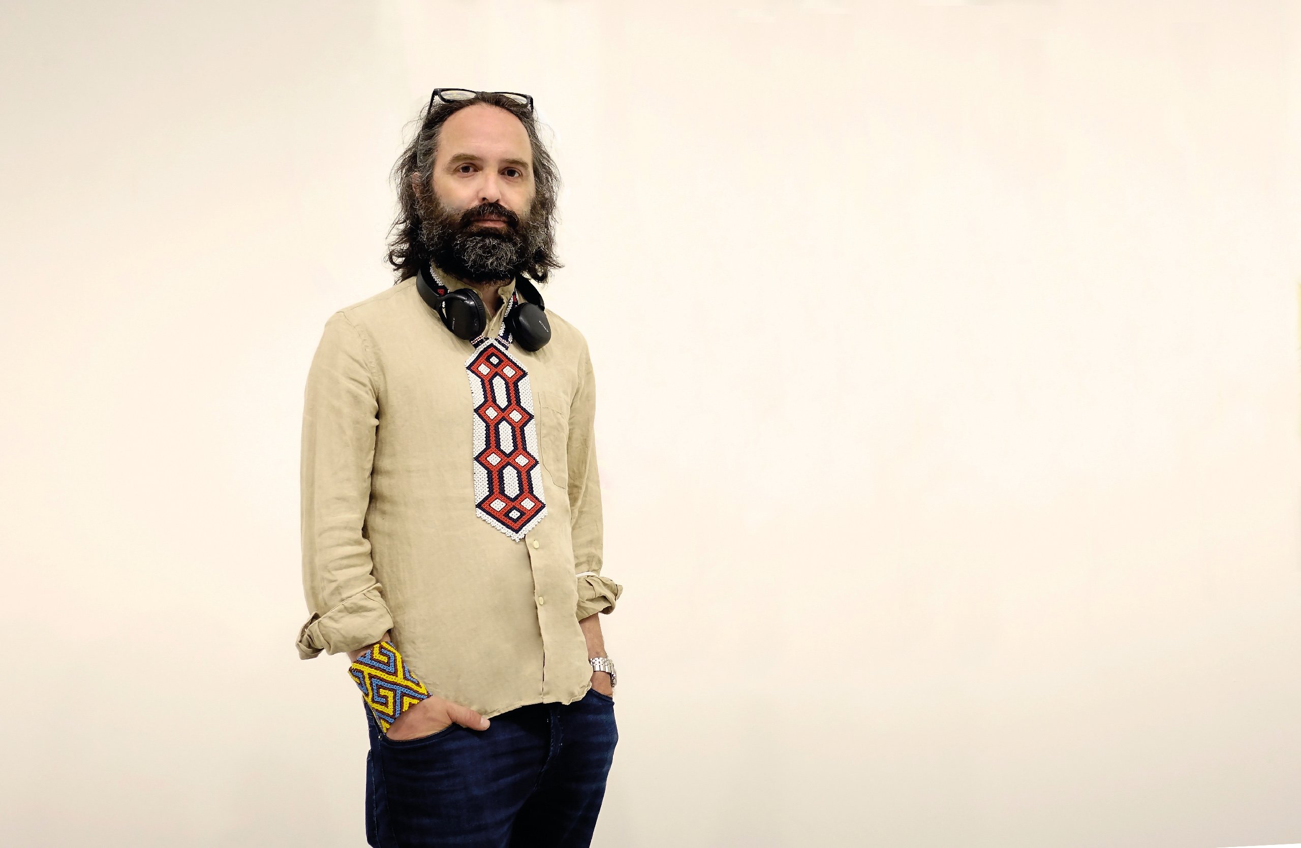 Waist-up portrait of Emanuele Coccia standing off to the left side against a plain beige background