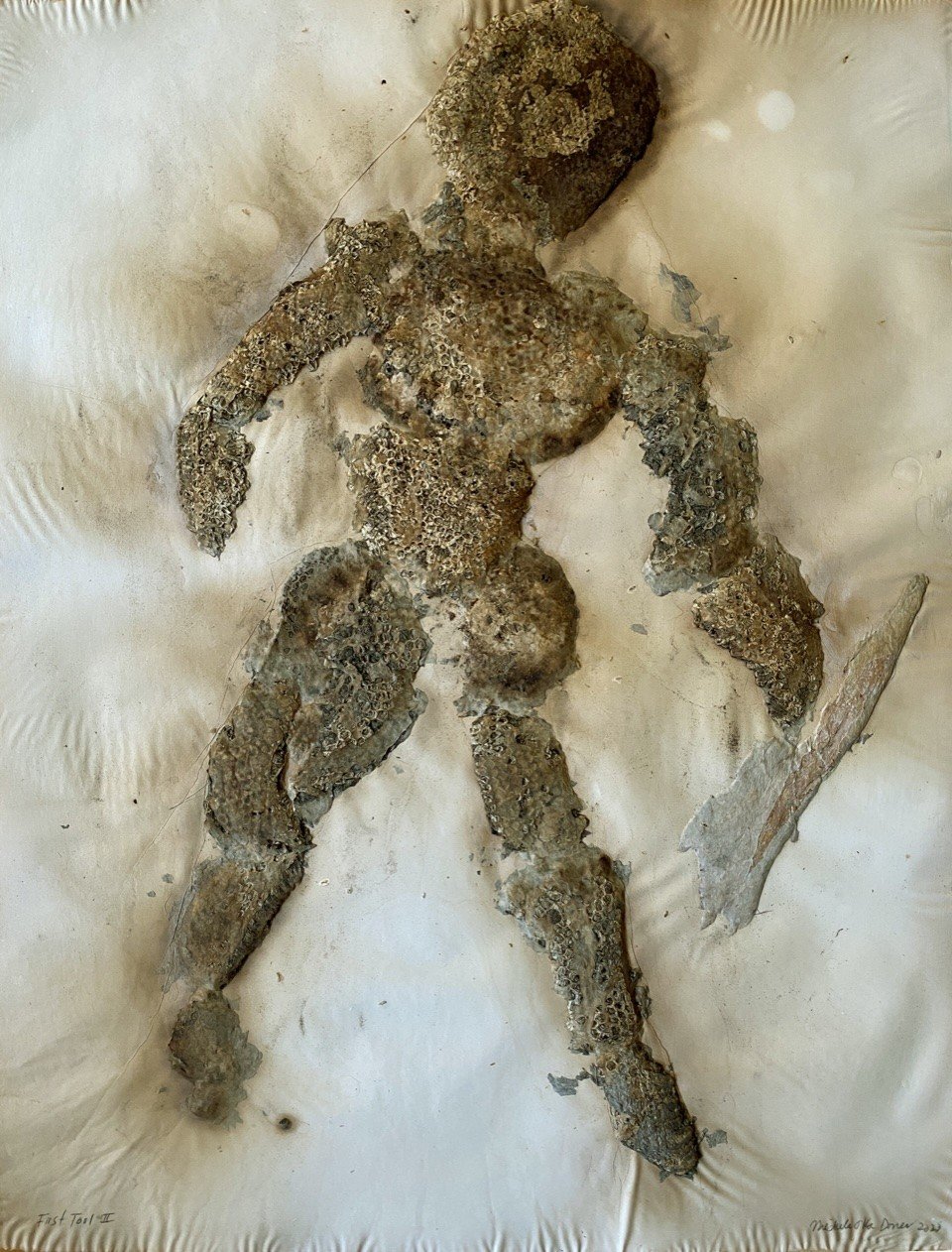Human form shaped out of dried-out beehive holding an ax-like form