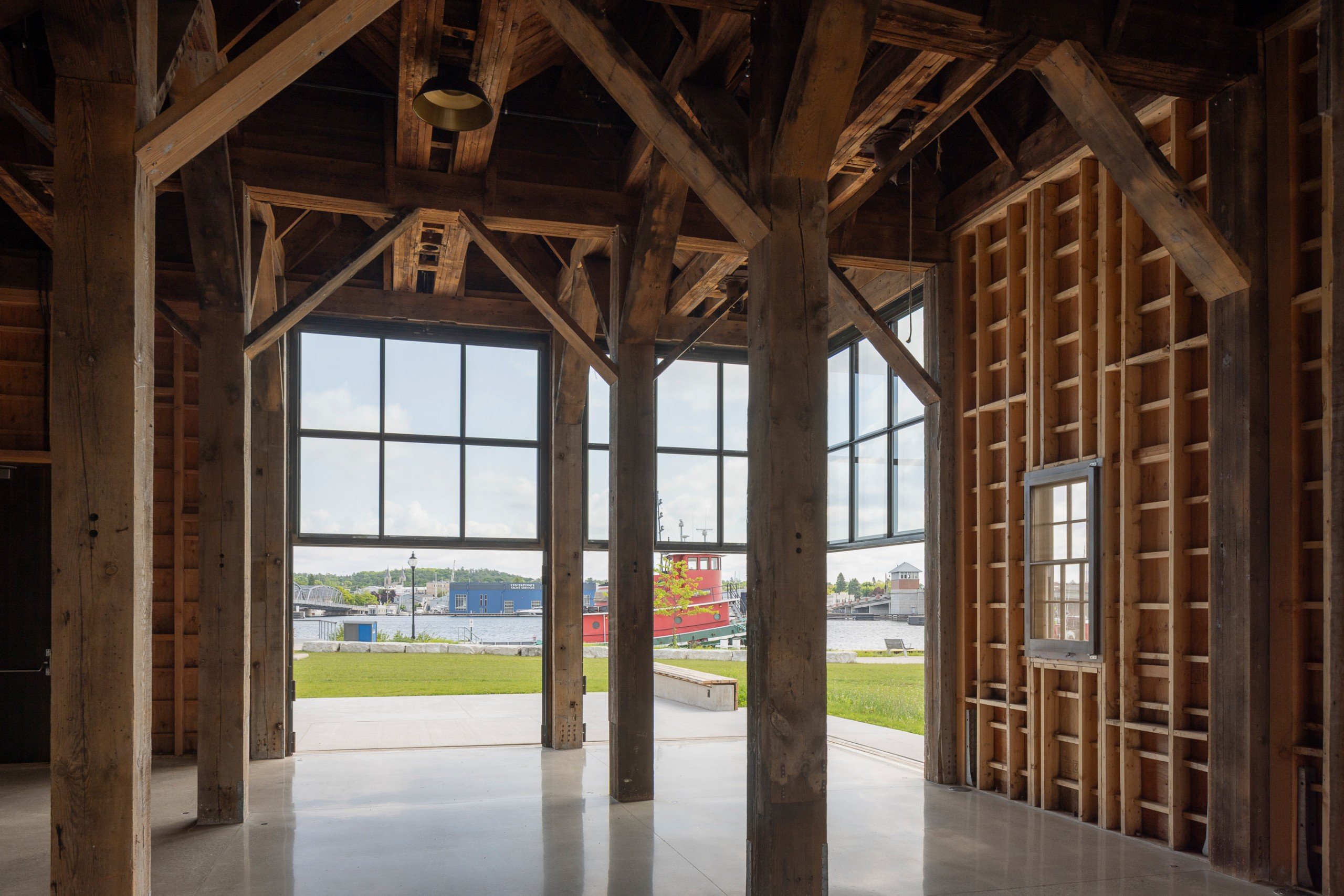 Wooden interior of renovated Door County Granary with three large pass-through windows half open