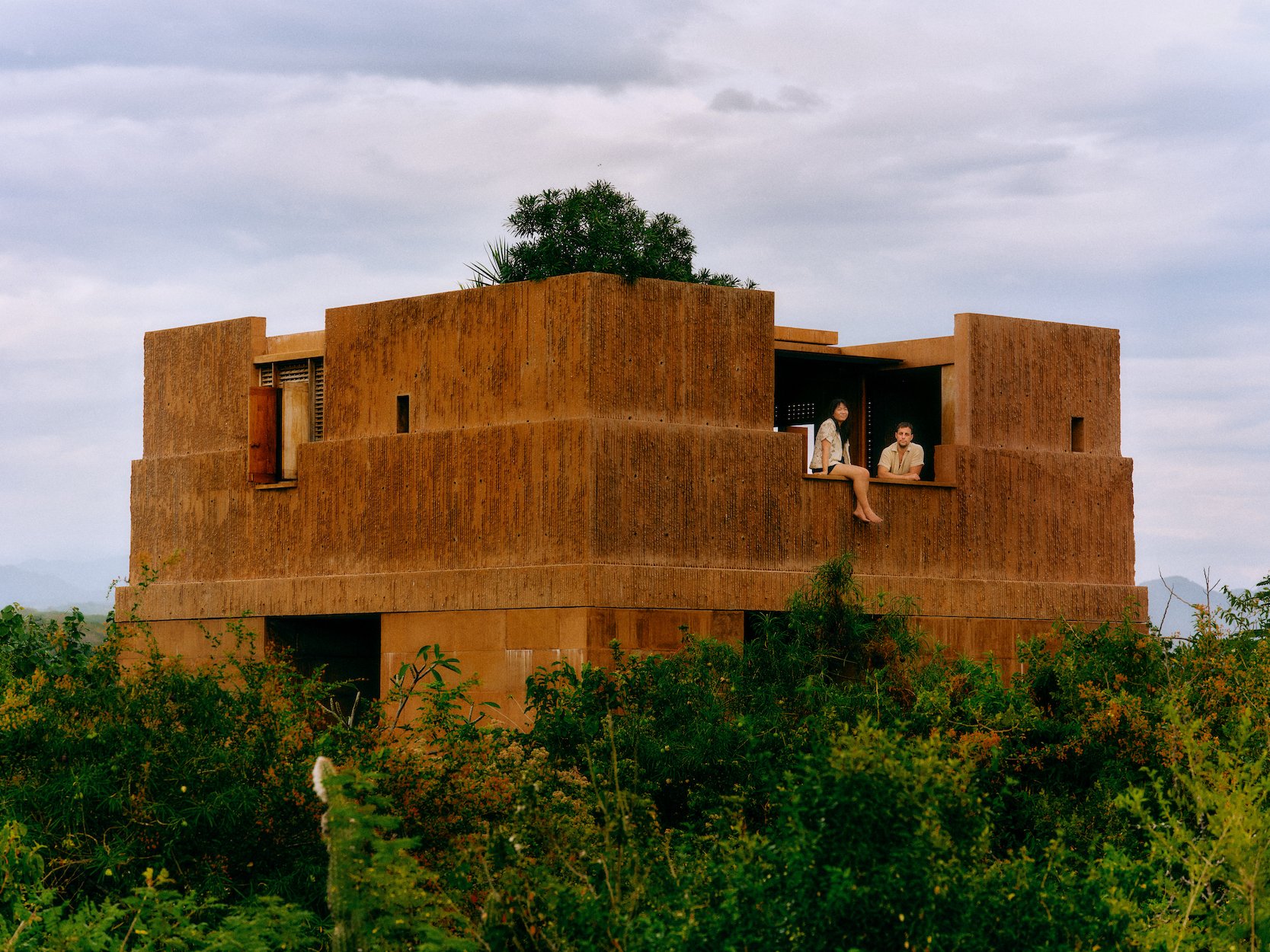 Exterior wide shot of Casa Monte with In Common With founders perched on an upper ledge