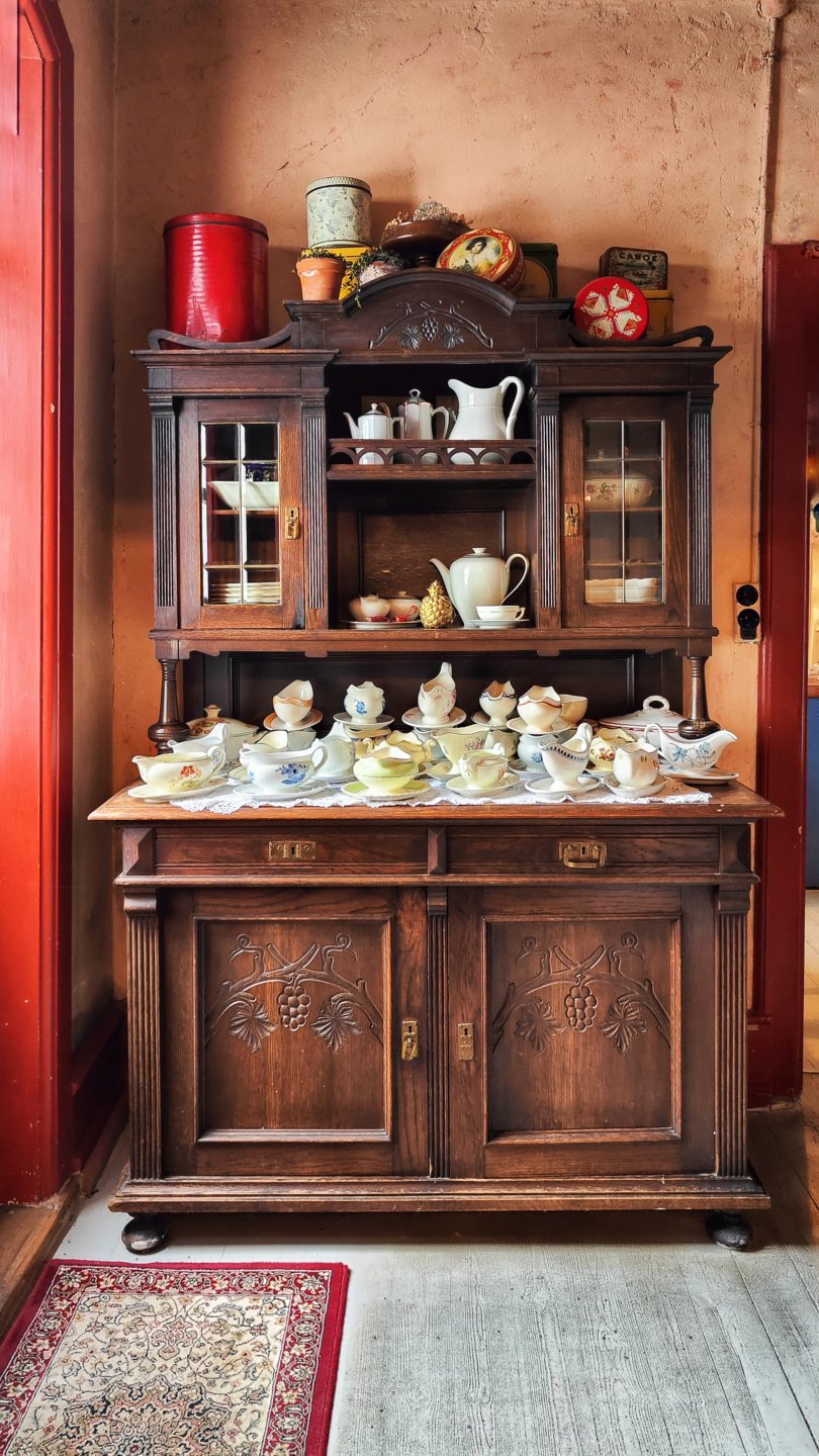 Antique wooden china cabinet filled with China