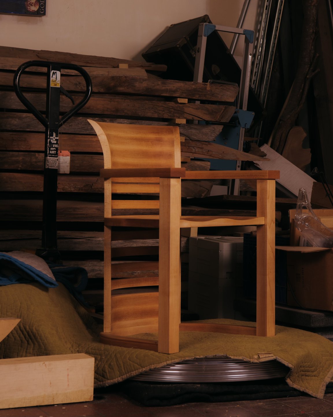 Wooden chair designed by Ryan Preciado with knick knacks around it in the background
