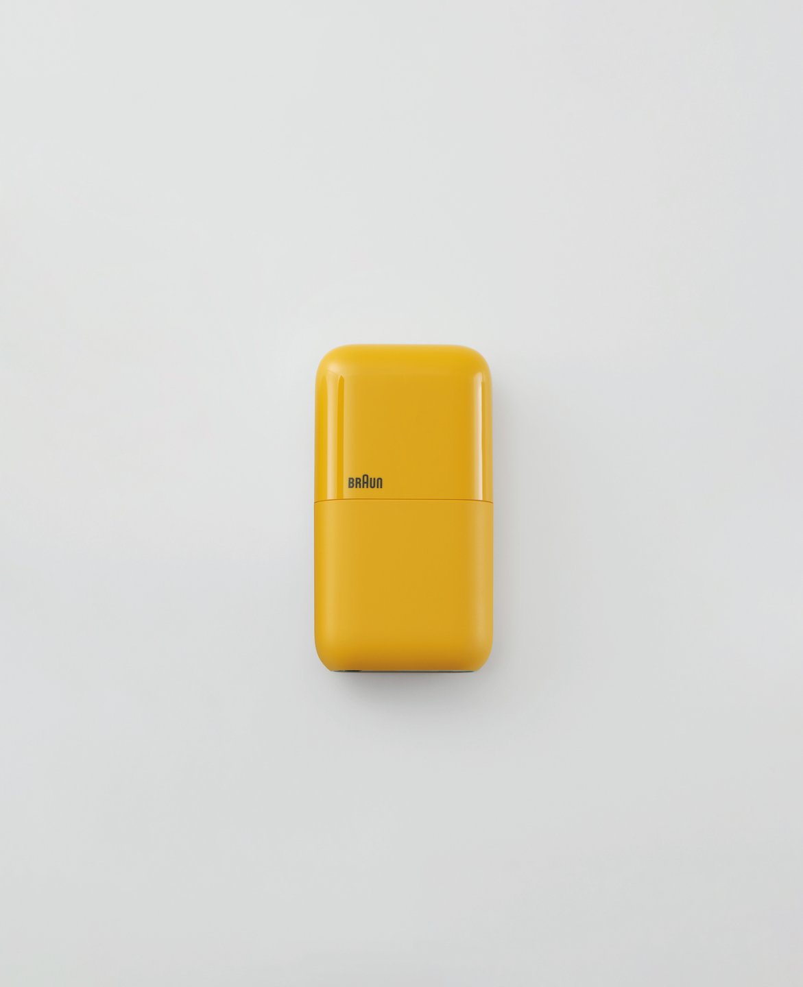 small rectangular yellow pocket shaver against plain light background