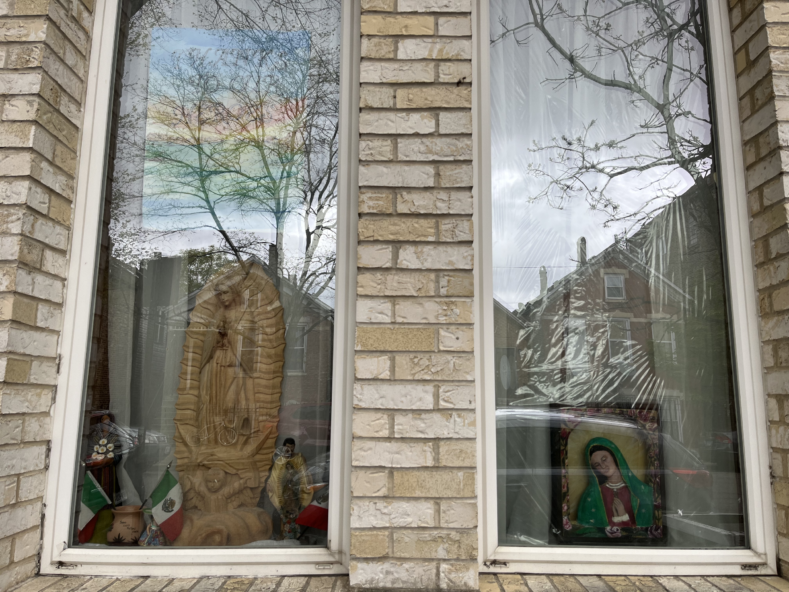 A window with religious figurines in it.