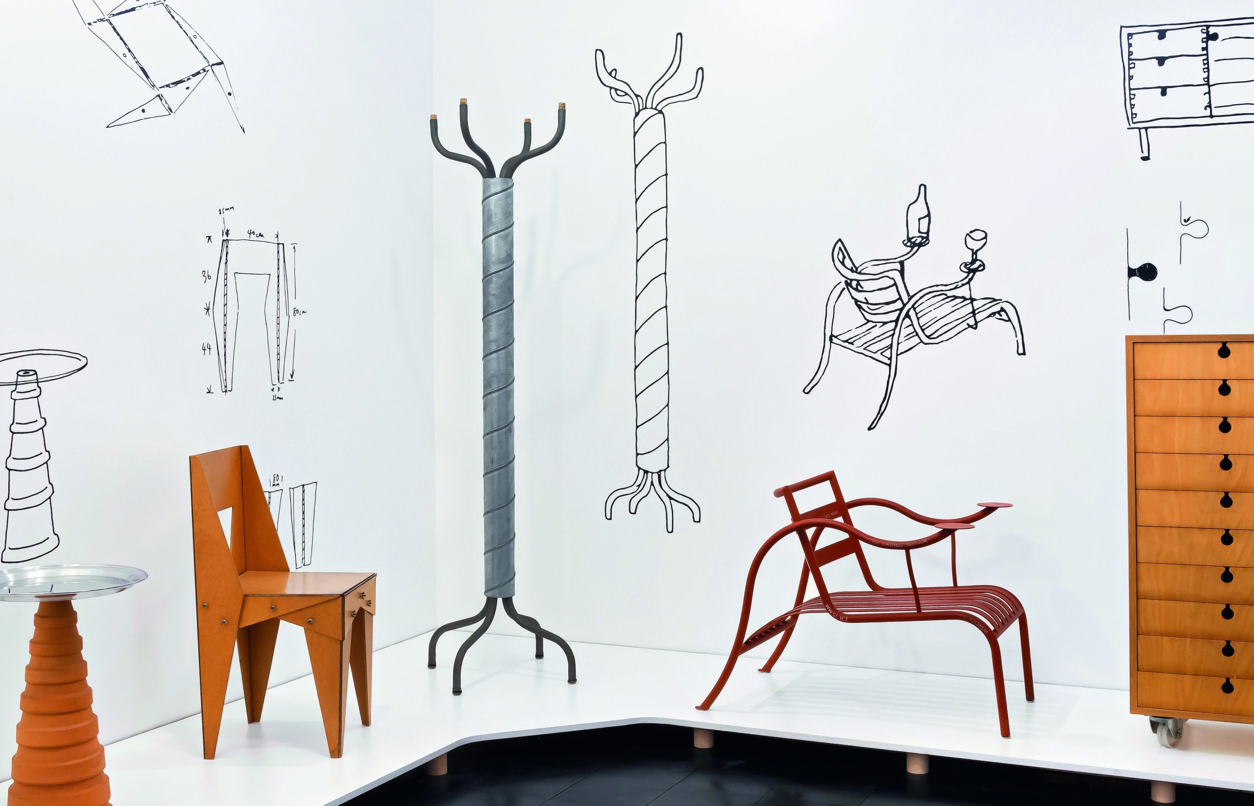 Several pieces of furniture by Jasper Morrison sitting in a white room with large sketches of the objects on the walls