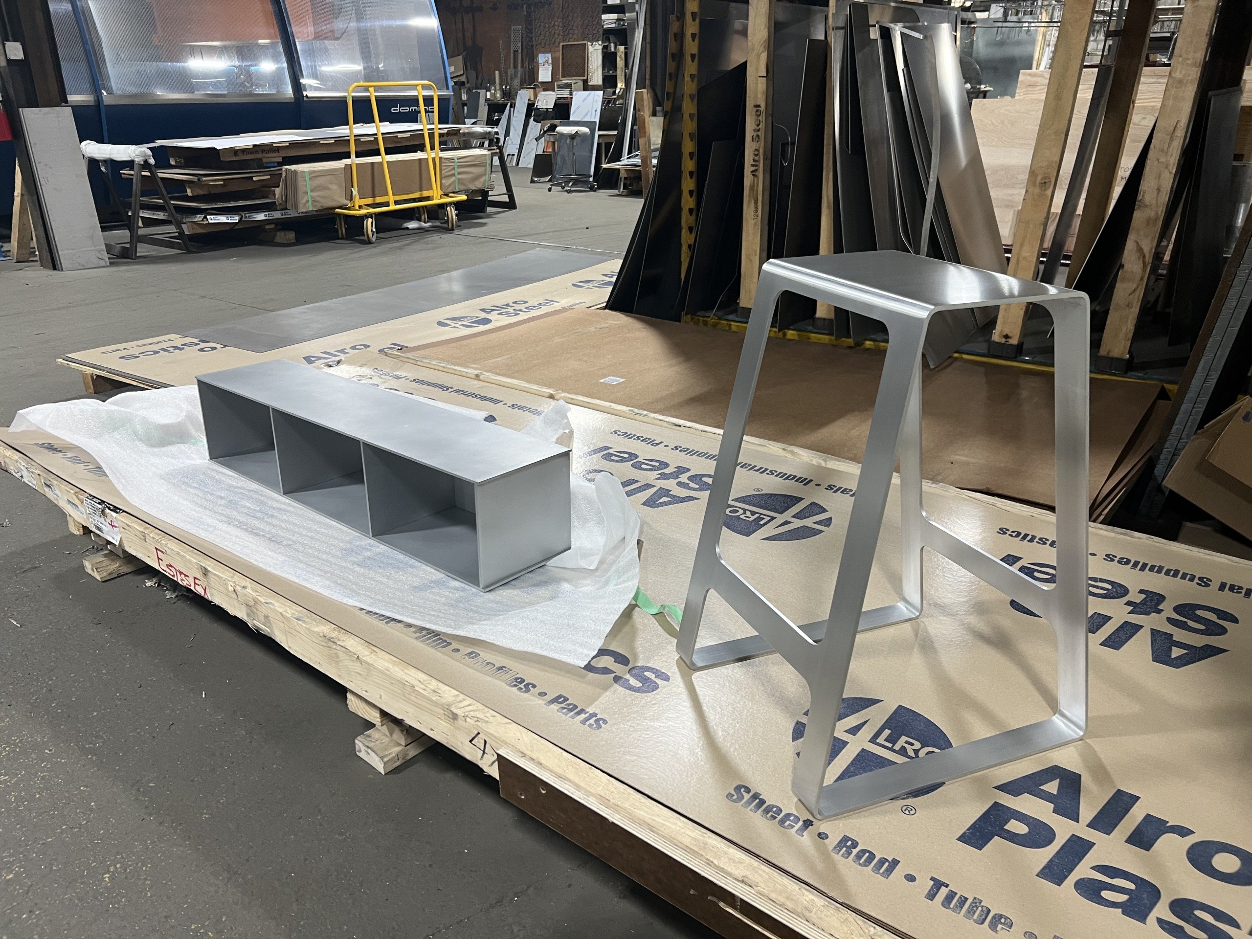 Minimalist silver shelf and stool by Jonathan Nesci in his workshop