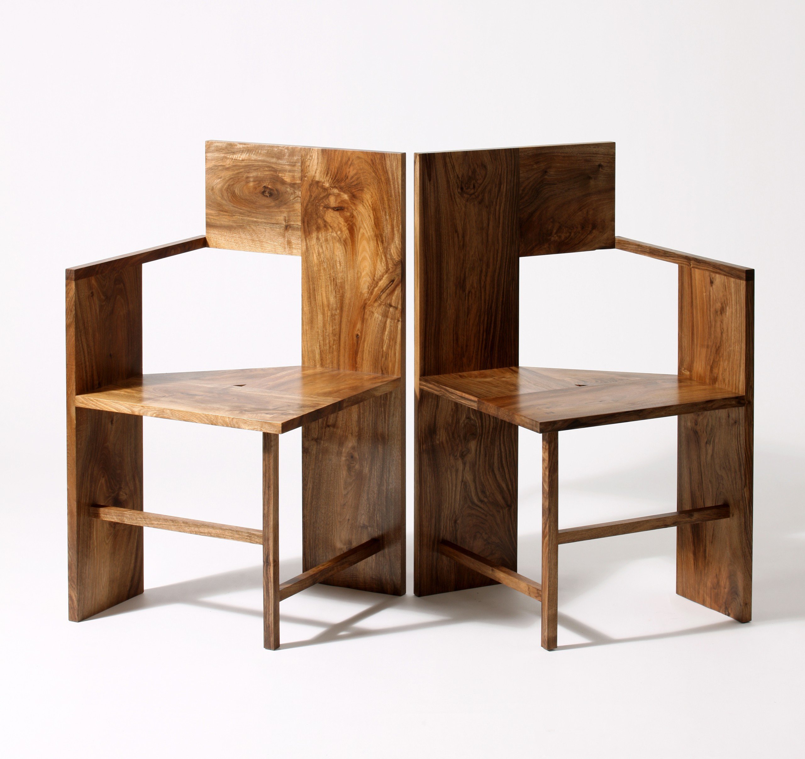 Two wood chairs back to back on a white background