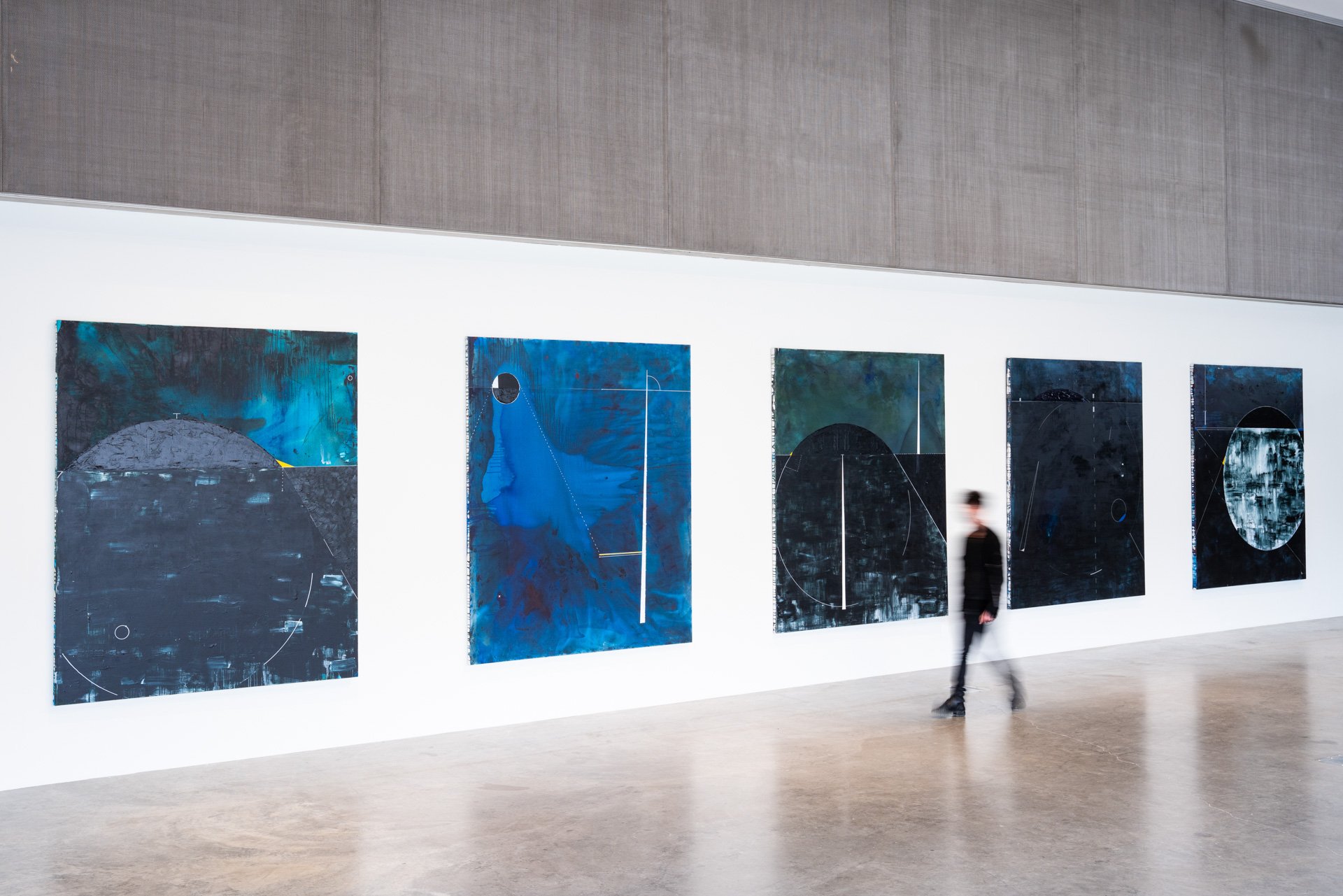 Installation view of blurred person walking by Dyson’s “Stories of Resistance” (2021) paintings